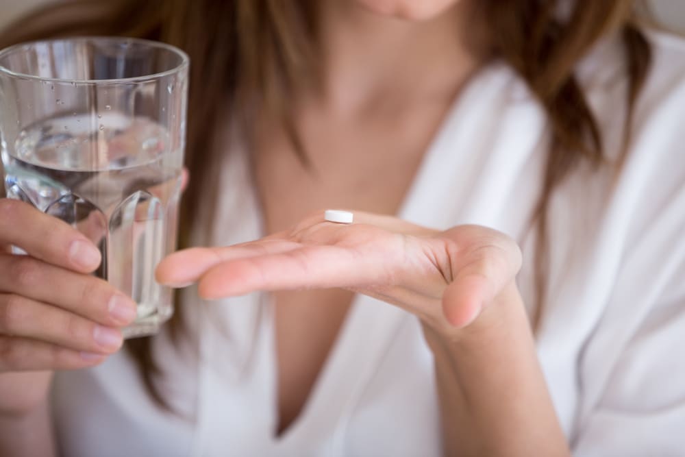 Woman holds medication to block alcohol effects in her hand